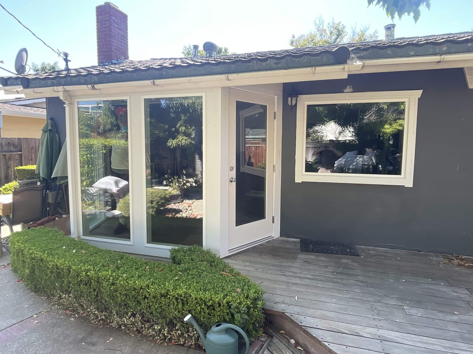 Patio sliding door with picture window on dark home exterior, East Bay