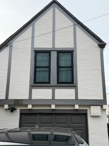 Black aluminum windows on Tudor-style home with garage, East Bay