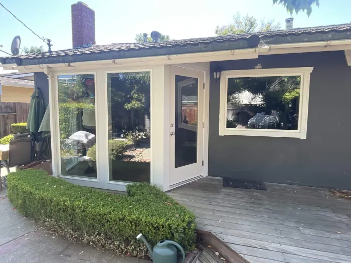 New patio sliding door with flanking picture windows on dark home, East Bay