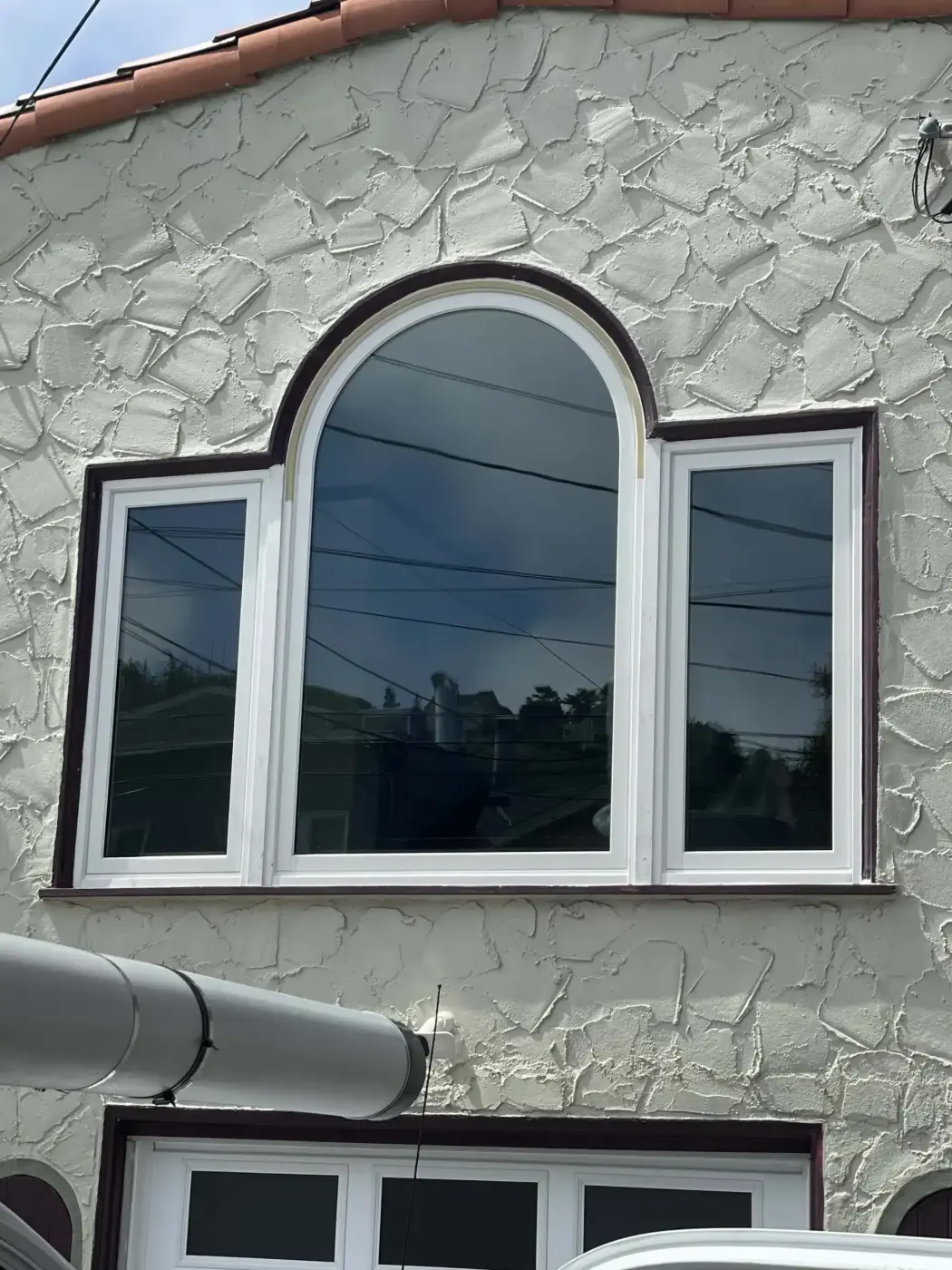 New arched window set in a stucco wall, installed by Windows 4U