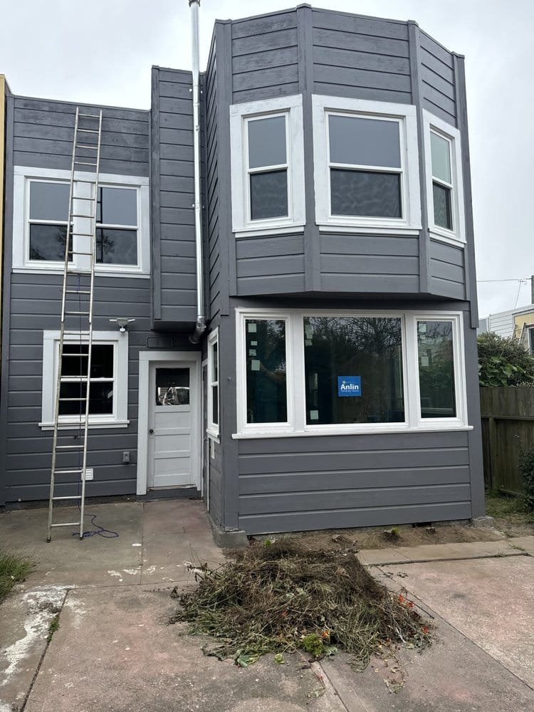 White vinyl windows installed on dark gray home exterior, East Bay